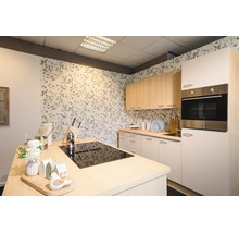Cuisine moderne et lumineuse avec un îlot central équipé d'une plaque de cuisson noire, meubles hauts en bois clair et papier peint floral.