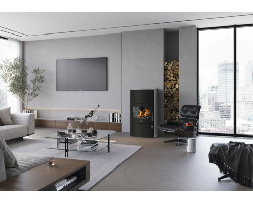Salon moderne et lumineux avec poêle à bois noir, niche de stockage de bois, table basse en verre et grande fenêtre avec vue sur la ville.