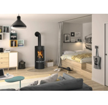 Poêle à bois noir moderne dans un espace de vie et de nuit clair et ouvert avec parquet en bois clair et atmosphère chaleureuse.