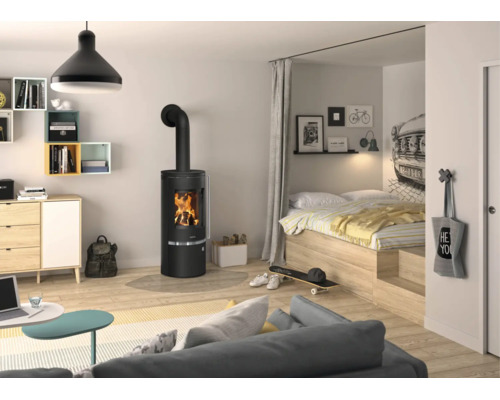 Poêle à bois noir moderne dans un espace de vie et de nuit clair et ouvert avec parquet en bois clair et atmosphère chaleureuse.