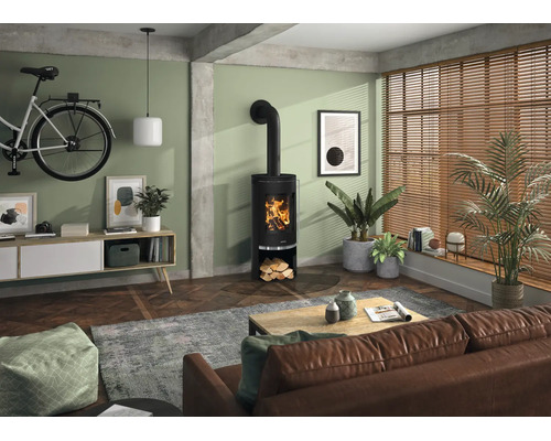 Moderner Kaminofen in einem hellen Wohnzimmer mit Parkettboden, Ledersofa und grossen Fenstern mit Holzjalousien.