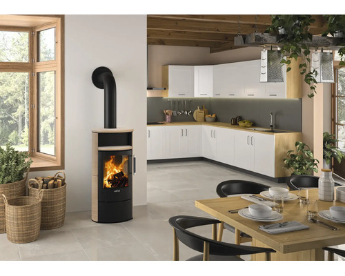 Kaminofen mit Sichtscheibe in einer hellen, modernen Küche mit Essbereich, Holzbalkendecke und dekorativen Körben.