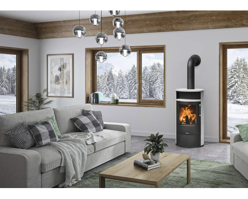 Salon moderne avec poêle à bois autoportant en acier noir avec habillage blanc, canapé gris, table basse en bois et grandes fenêtres.