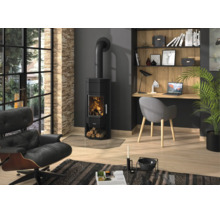 Salon moderne avec poêle à bois noir avec feu, parquet en bois, chaise de bureau grise et fauteuil de relaxation en cuir noir.