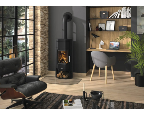 Salon moderne avec poêle à bois noir avec feu, parquet en bois, chaise de bureau grise et fauteuil de relaxation en cuir noir.