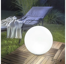 Lampe sphérique d'extérieur blanche sur une terrasse en bois dans un jardin à côté d'une chaise longue.