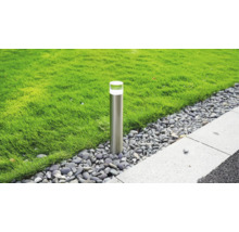 Borne d éclairage de jardin moderne en acier inoxydable dans un lit de gravier entre une pelouse et un chemin pavé.