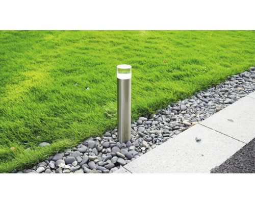 Borne d éclairage de jardin moderne en acier inoxydable dans un lit de gravier entre une pelouse et un chemin pavé.