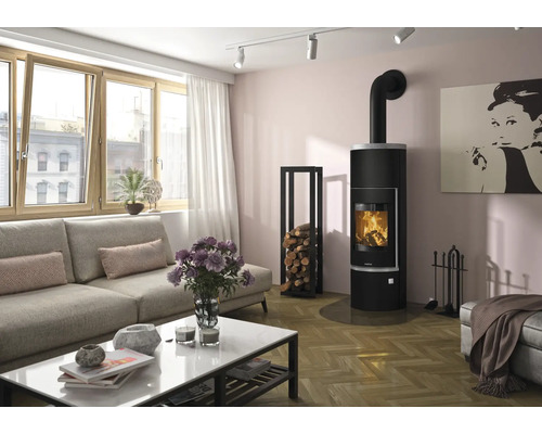 Poêle à bois noir moderne dans un salon lumineux avec parquet, canapé, table basse et porte-bûches.
