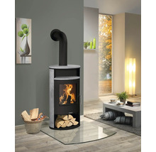 Poêle à bois Justus avec revêtement en pierre et feu de bois dans un salon de style moderne sur une plaque de sol en verre.