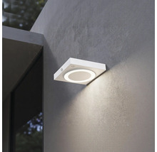 Applique murale extérieure LED carrée moderne avec détecteur de mouvement et anneau lumineux circulaire sur une façade texturée.