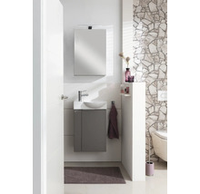 Modernes Gäste-WC Set mit grauem Unterschrank, weißem Waschbecken, Spiegel mit Beleuchtung und Natursteinwand.