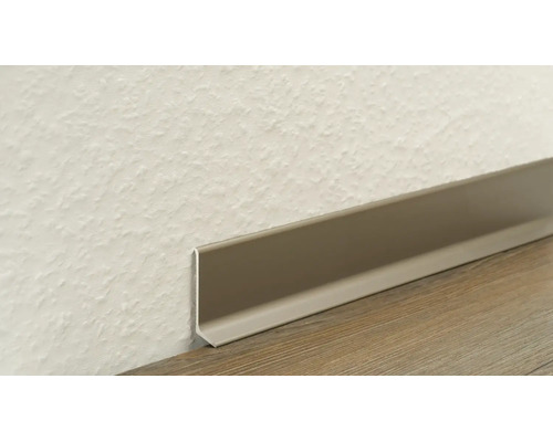 Kunststoff-Sockelleiste an einer strukturierten Wand und einem Boden mit Holzmaserung.