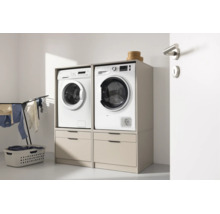 Deux meubles de machine à laver l'un à côté de l'autre avec tiroirs, sur lesquels se trouvent un lave-linge et un sèche-linge.