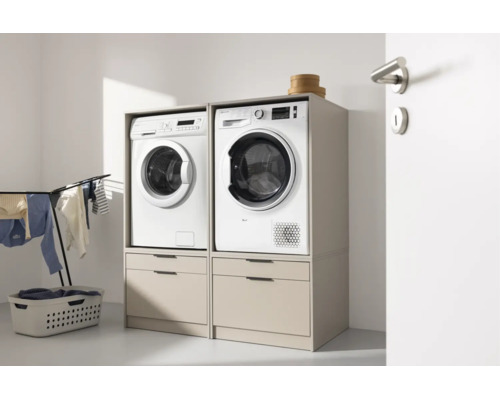 Deux meubles de machine à laver l'un à côté de l'autre avec tiroirs, sur lesquels se trouvent un lave-linge et un sèche-linge.