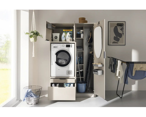 Buanderie lumineuse avec une armoire ouverte contenant un lave-linge, des espaces pour la lessive et des ustensiles de nettoyage.