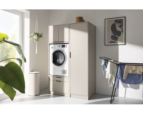 Buanderie moderne et lumineuse avec un meuble pour lave-linge beige, une armoire haute, un lave-linge, un séchoir et des plantes.