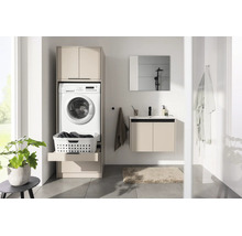 Salle de bains lumineuse avec armoire pour lave-linge beige, lave-linge, tablette coulissante pour panier à linge et meuble sous-vasque assorti.