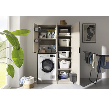 Armoire de buanderie beige avec lave-linge, portes ouvertes, étagères, paniers à linge et lessive dans une pièce lumineuse.