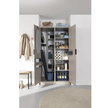 Armoire utilitaire ouverte avec des compartiments organisés pour planche à repasser, produits ménagers et provisions.