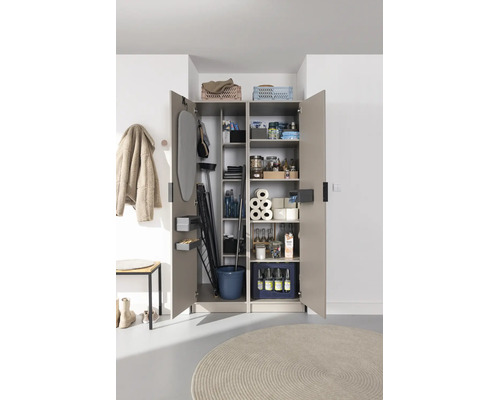 Armoire utilitaire ouverte avec des compartiments organisés pour planche à repasser, produits ménagers et provisions.