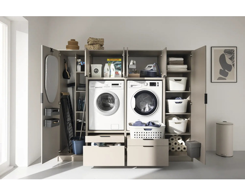 Armoire de buanderie spacieuse en bois avec lave-linge, sèche-linge intégrés, tiroirs et grand espace de rangement pour le ménage.