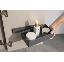 Une boîte de rangement grise avec des cosmétiques est suspendue à un support à l'intérieur d'une porte de placard.