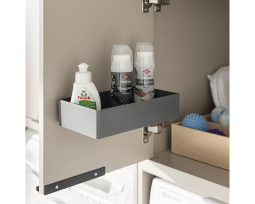 Boîte de rangement grise montée sur une porte d'armoire contenant des produits d'entretien, idéale pour l'organisation.