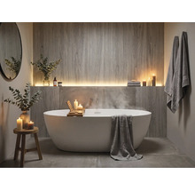 Salle de bains moderne avec une baignoire îlot ovale, un revêtement mural aspect bois et un éclairage indirect.
