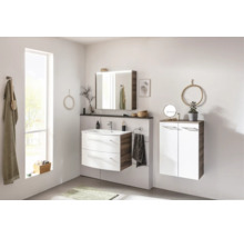 Ensemble de meubles de salle de bain moderne, aspect bois et blanc, avec lavabo, armoire de toilette et meuble suspendu.