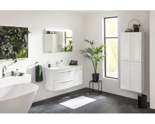 Salle de bain moderne et lumineuse avec meuble sous vasque, miroir éclairé, armoire haute suspendue et baignoire îlot.