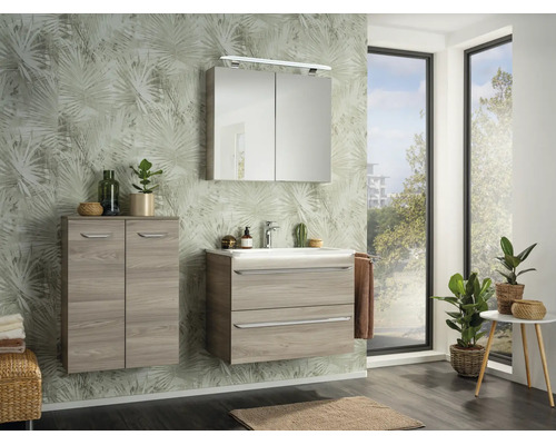 Salle de bains moderne avec meuble sous-vasque aspect bois, armoire de toilette, meuble suspendu et papier peint à motif de palmes.