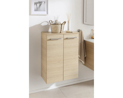 Meuble de salle de bain suspendu aspect bois clair avec deux portes et poignées argentées.