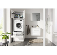 Salle de bains moderne et lumineuse avec meuble pour lave-linge blanc, meuble sous lavabo, miroir et plante verte.