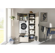 Armoire pour lave-linge beige avec sèche-linge intégré, portes ouvertes, tiroir, étagères, paniers, fer à repasser et séchoir.