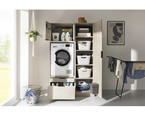 Armoire pour lave-linge beige avec sèche-linge intégré, portes ouvertes, tiroir, étagères, paniers, fer à repasser et séchoir.