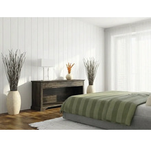 Chambre lumineuse avec panneaux muraux verticaux blancs, un buffet en bois sombre et un lit avec couvre-lit à rayures vertes.