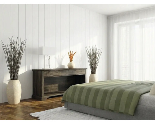 Chambre lumineuse avec panneaux muraux verticaux blancs, un buffet en bois sombre et un lit avec couvre-lit à rayures vertes.