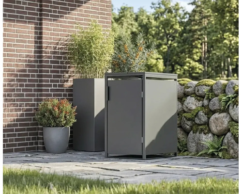 Cache-poubelle moderne en métal et jardinière assortie sur une terrasse pavée à côté d'un mur en briques et d'un mur en pierres naturelles.