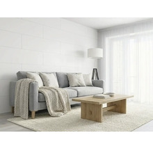 Salon lumineux avec canapé gris, table basse en bois, panneaux muraux blancs et jeté de canapé en tricot de style scandinave.