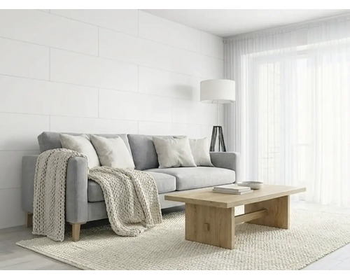 Salon lumineux avec canapé gris, table basse en bois, panneaux muraux blancs et jeté de canapé en tricot de style scandinave.