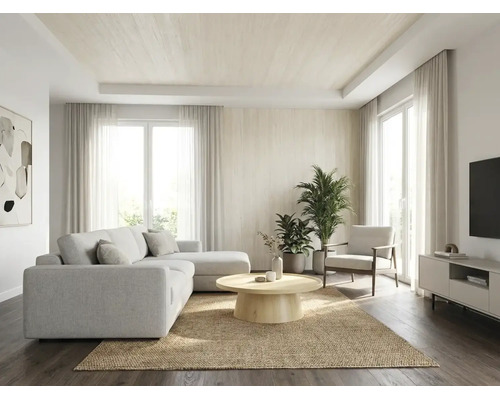Salon lumineux et spacieux avec canapé d'angle clair, table ronde en bois sur tapis en jute, plantes d'intérieur et grandes fenêtres avec rideaux.