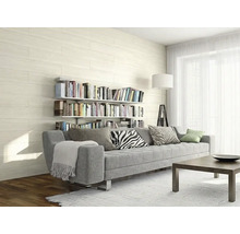 Salon moderne et clair avec des carreaux muraux aspect bois, un canapé gris, des étagères de livres et un lampadaire.