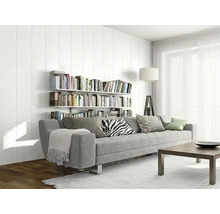 Salon moderne et lumineux avec un grand canapé gris, des étagères murales remplies de livres, une table basse en bois et de grandes fenêtres.