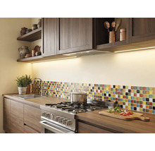 Cuisine moderne avec meubles en bois foncé, éclairage sous placard, cuisinière en acier inoxydable et crédence mosaïque sur plan de travail en bois.
