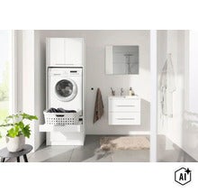 Armoire blanche pour lave-linge dans une salle de bain claire, avec tiroir pour panier à linge et meuble vasque. (Image AI modified or generated)