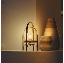 Lampe de table moderne en forme de lanterne, verre et métal, lumière chaude près de deux vases en céramique texturés sur une étagère.