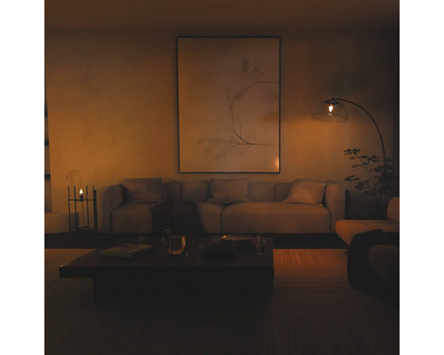 Salon moderne avec un grand tableau mural, un canapé en tissu et un lampadaire à arc avec abat-jour en verre dans une ambiance chaleureuse.