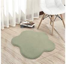 Blumenförmiger Plüschteppich in einem hellen Zimmer mit hellem Holzboden, einem modernen weißen Stuhl und weißen Vorhängen.