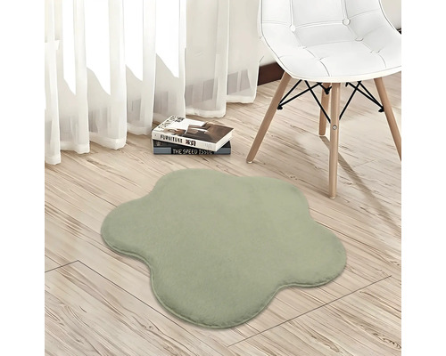 Blumenförmiger Plüschteppich in einem hellen Zimmer mit hellem Holzboden, einem modernen weißen Stuhl und weißen Vorhängen.